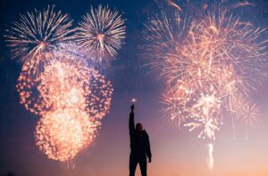 Csillagszórózó férfi háttérben tűzijátékkal